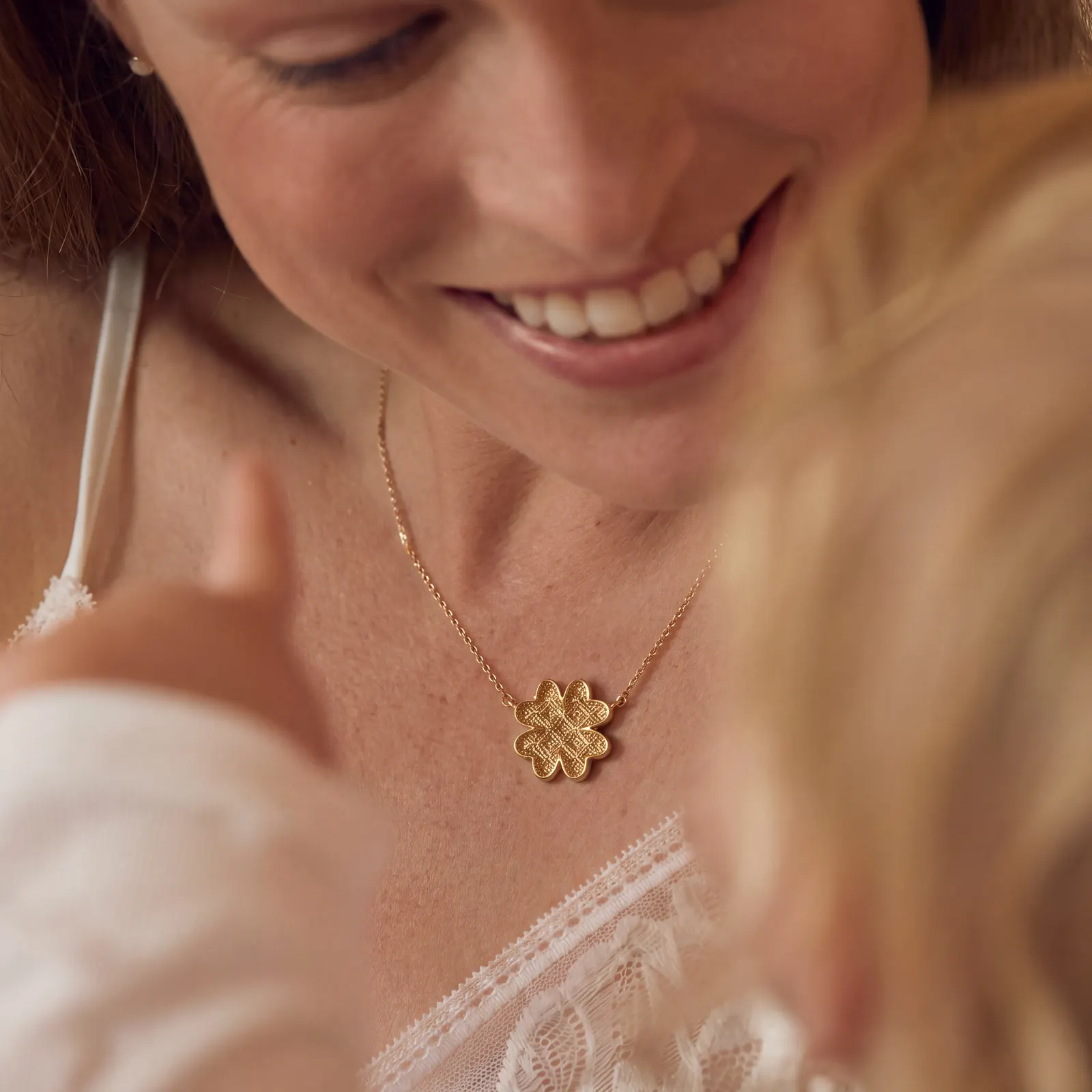 AI jewelry photoshoot: gold clover necklace on smiling model